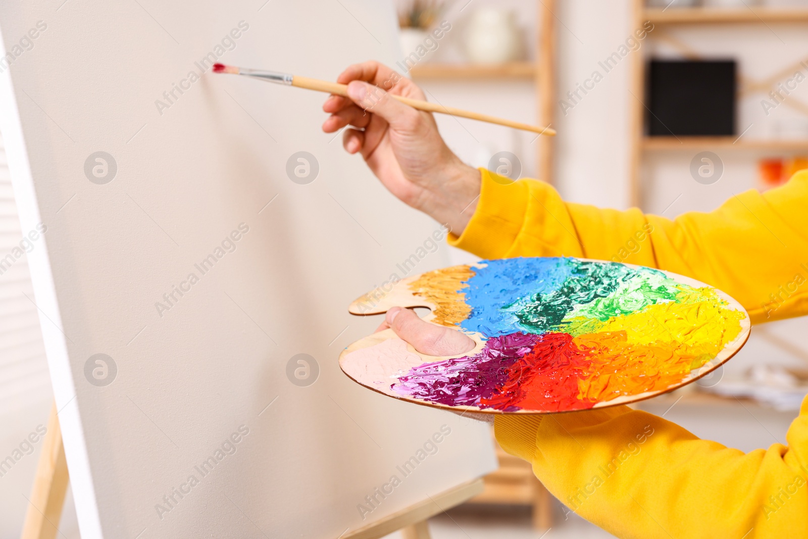 Photo of Man painting on canvas in studio, closeup