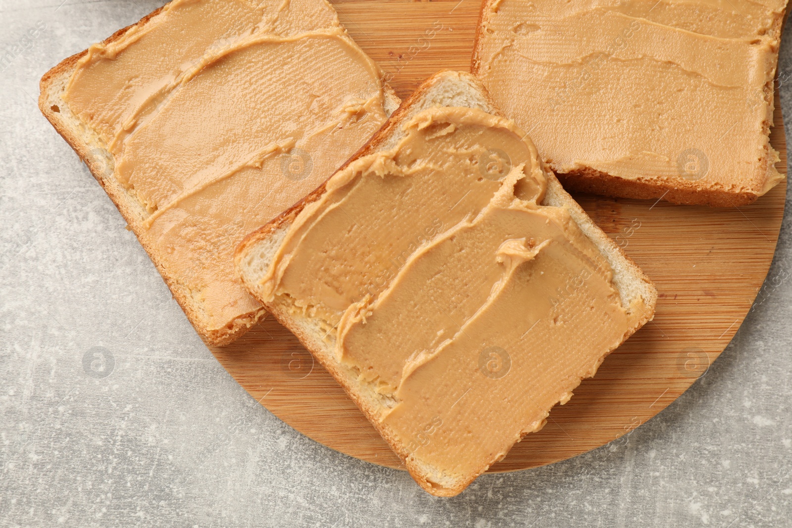 Photo of Tasty peanut butter sandwiches on gray table, top view