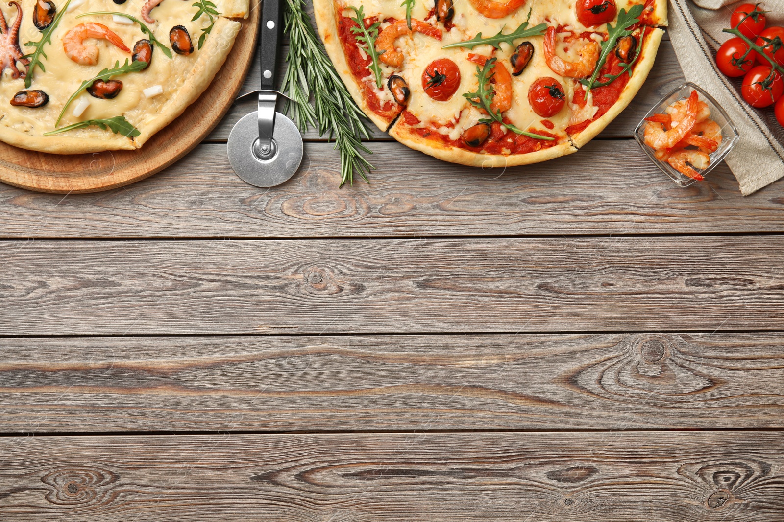 Photo of Delicious seafood pizza on wooden table, flat lay. Space for text