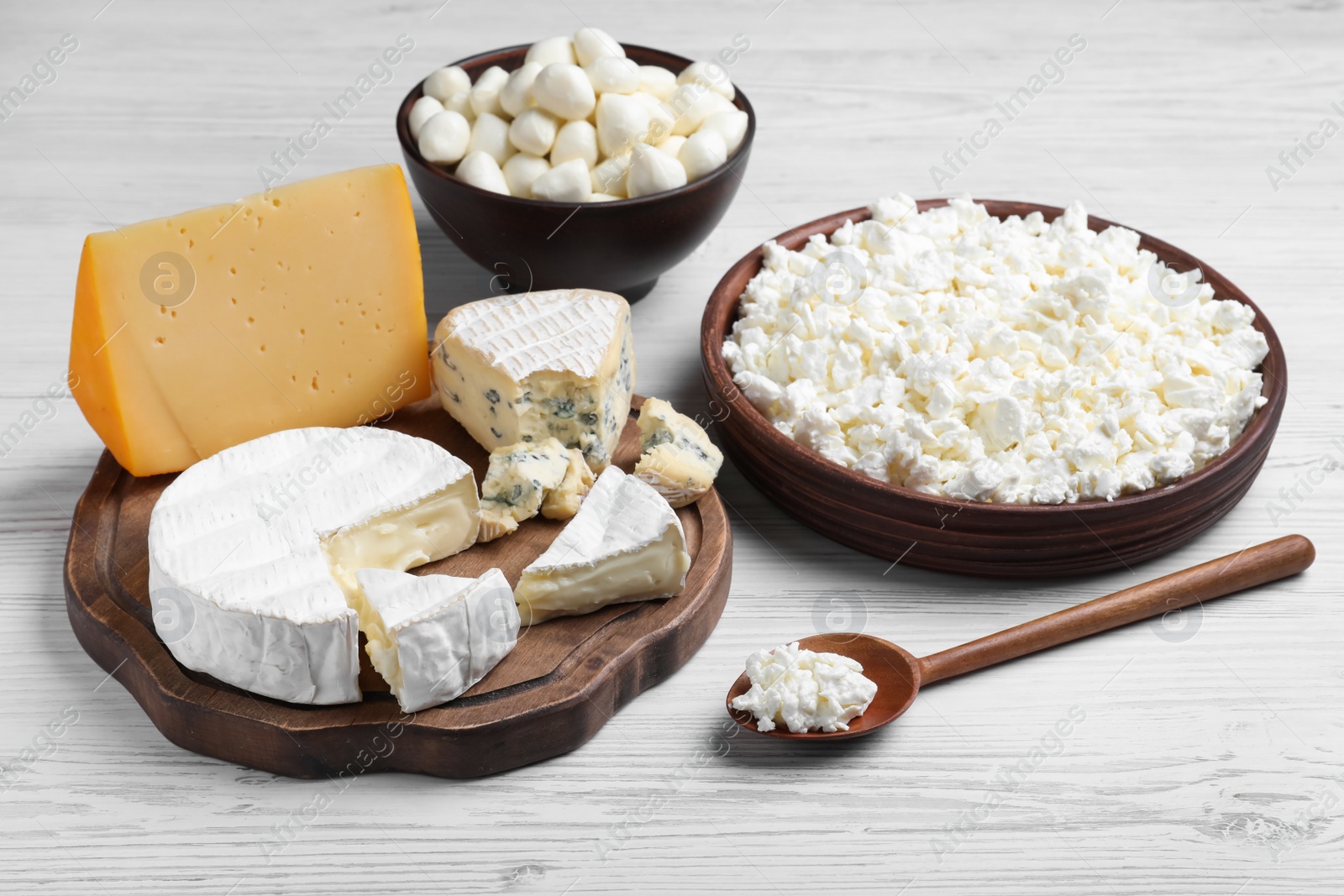 Photo of Clay dishware with fresh dairy products on white wooden table