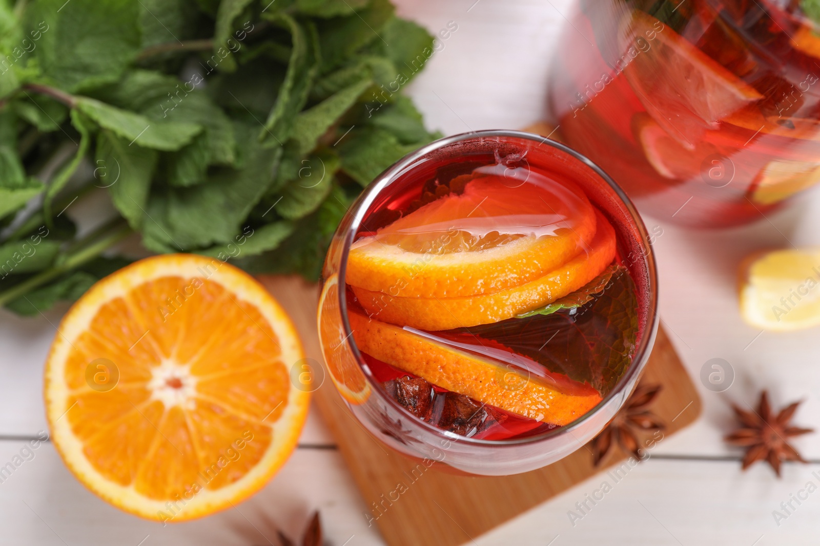 Photo of Delicious punch drink and ingredients on white table, flat lay