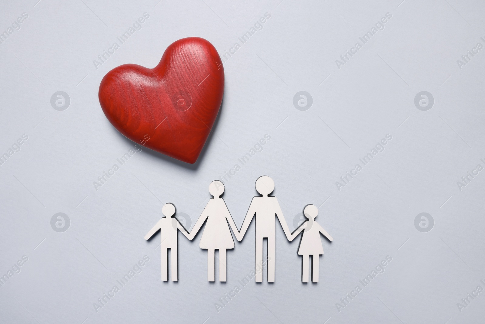 Photo of Figures of family and heart on light background, top view. Insurance concept