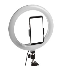 Photo of Modern tripod with ring light and smartphone isolated on white