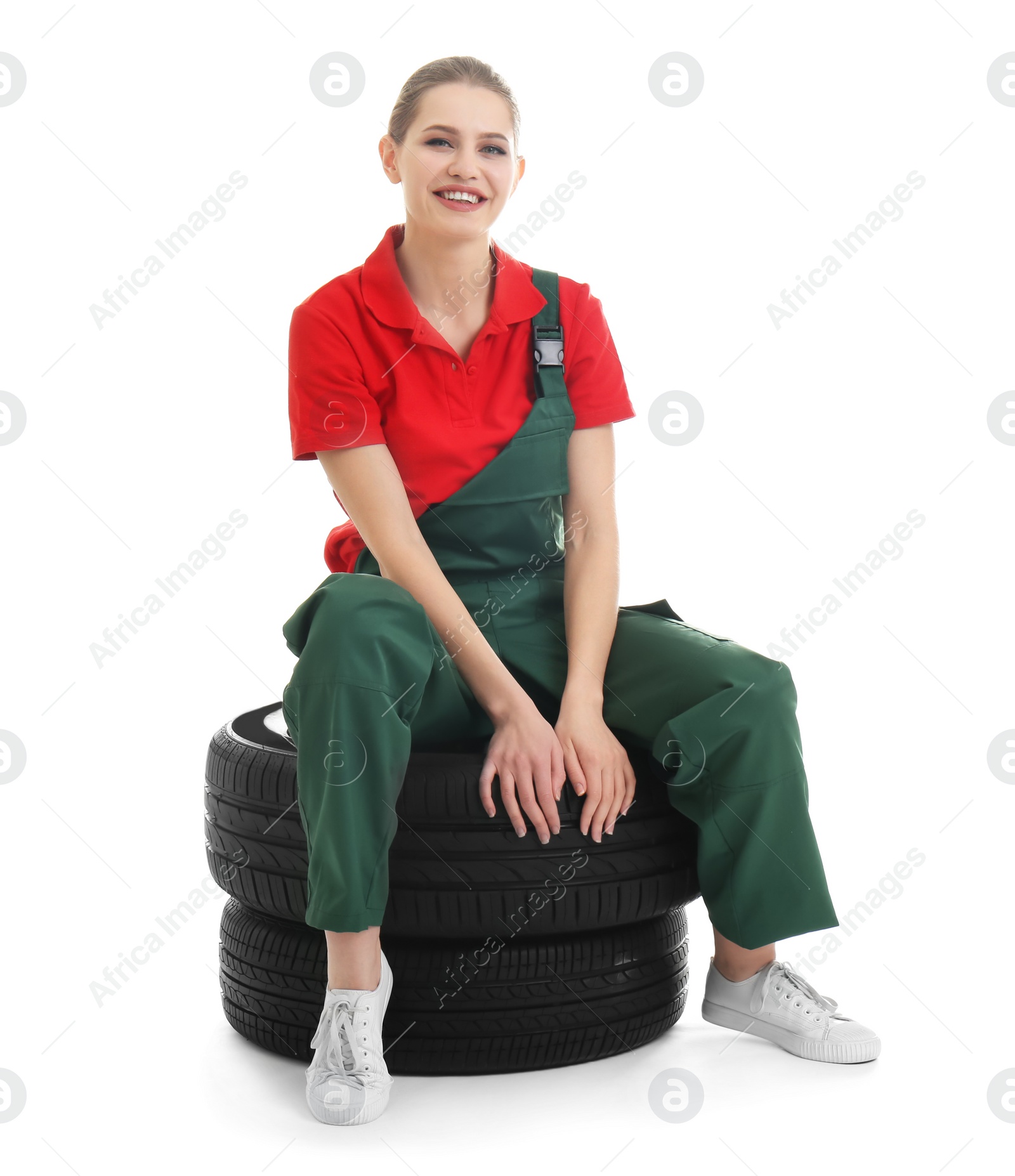 Photo of Female mechanic with car tires on white background