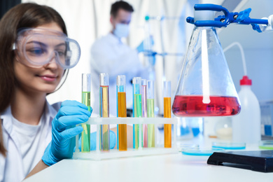 Scientist taking test tube from rack indoors. Laboratory analysis