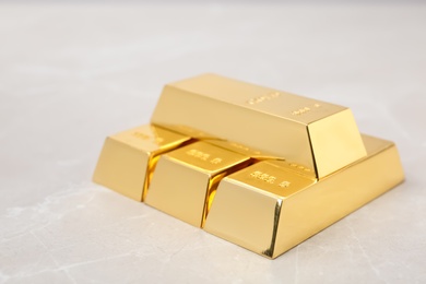 Photo of Stack of shiny gold bars on table