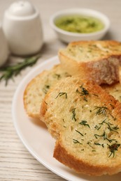Photo of Tasty baguette with garlic and dill on white table, closeup