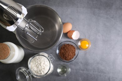 Stand mixer and different ingredients for dough on grey table, flat lay