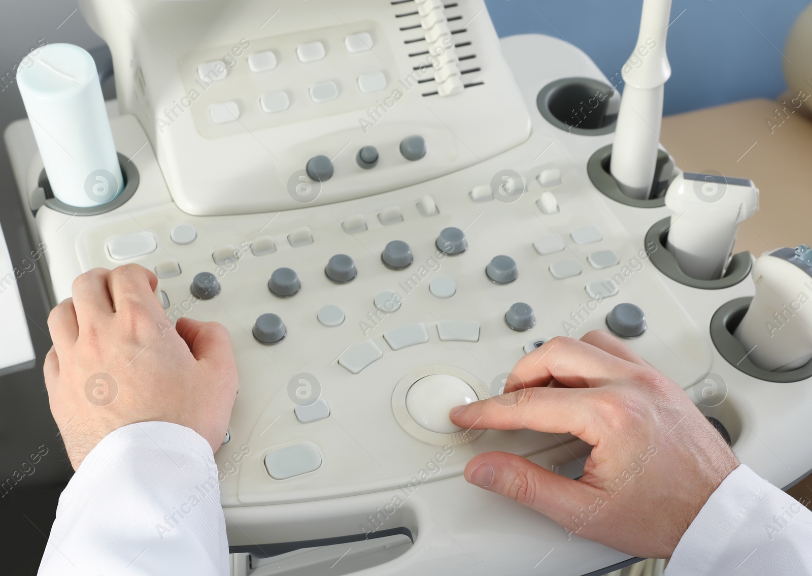 Photo of Sonographer operating modern ultrasound machine in clinic, closeup