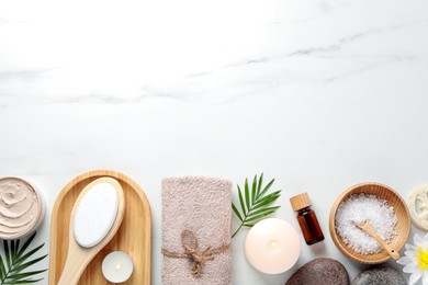 Flat lay composition with different spa products on white marble table. Space for text