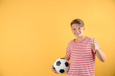 Photo of Teenage boy with soccer ball on color background