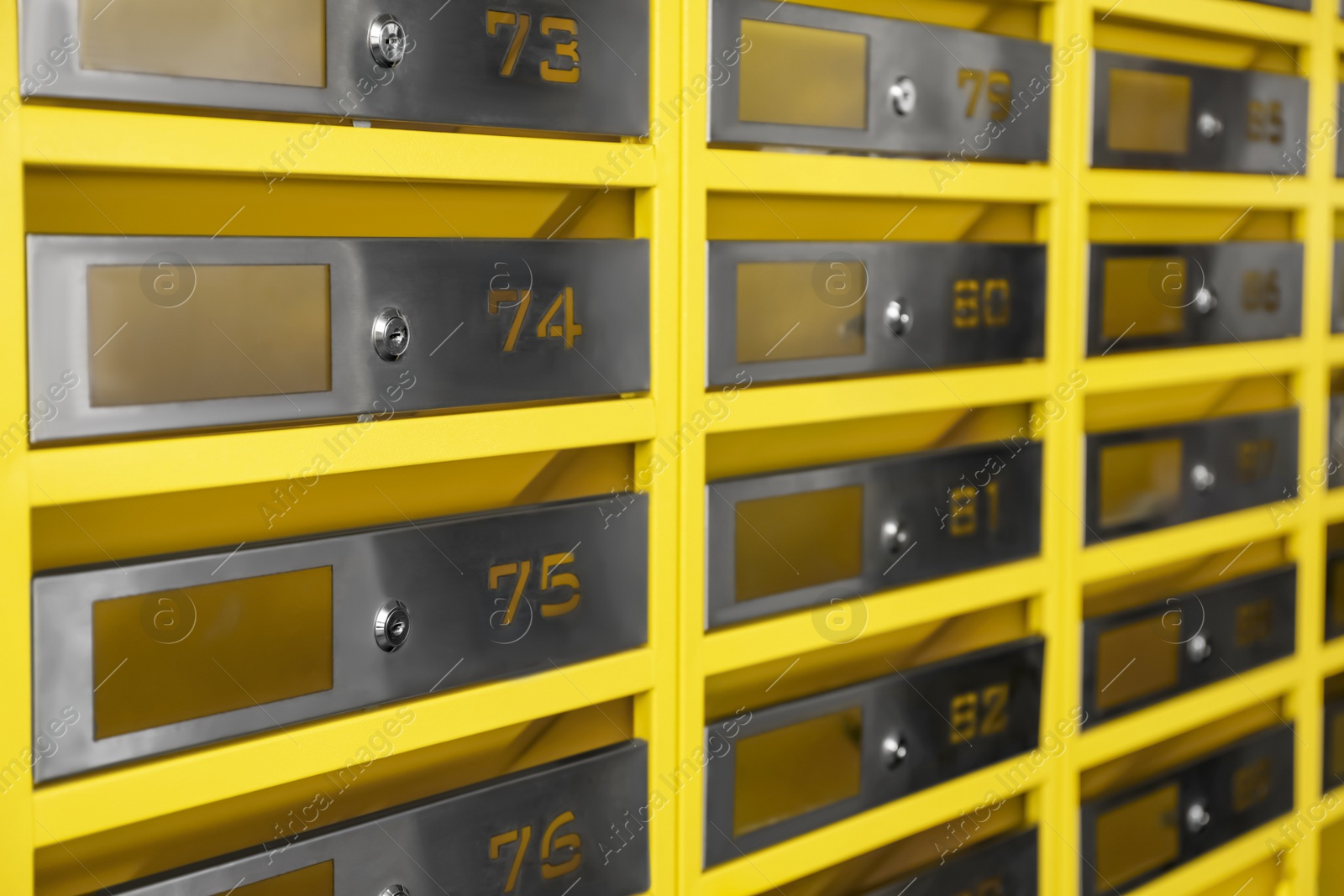 Photo of Many closed metal mailboxes with keyholes and numbers as background, closeup
