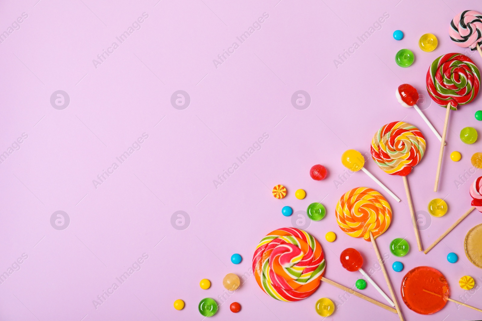 Photo of Flat lay composition with different candies and space for text on color background