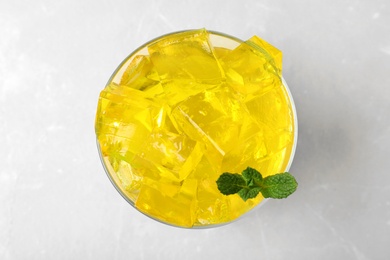 Photo of Glass bowl with tasty jelly cubes on table, top view