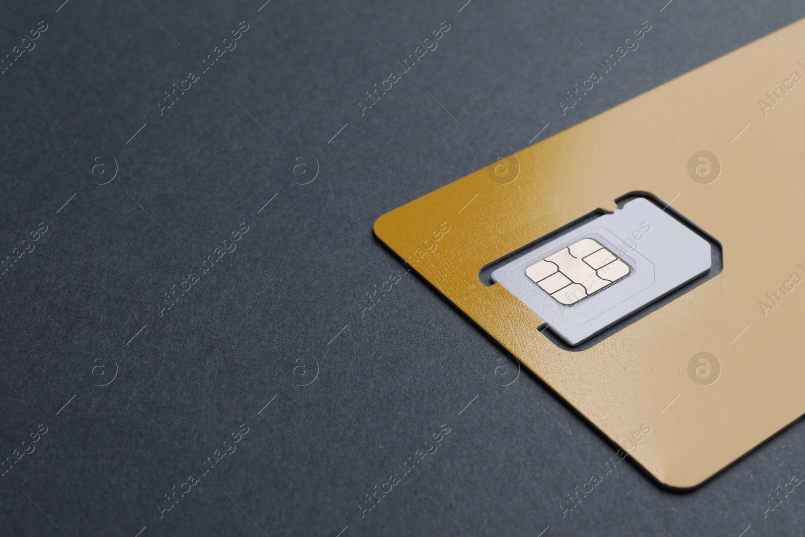 Photo of Yellow SIM card on black table, closeup. Space for text