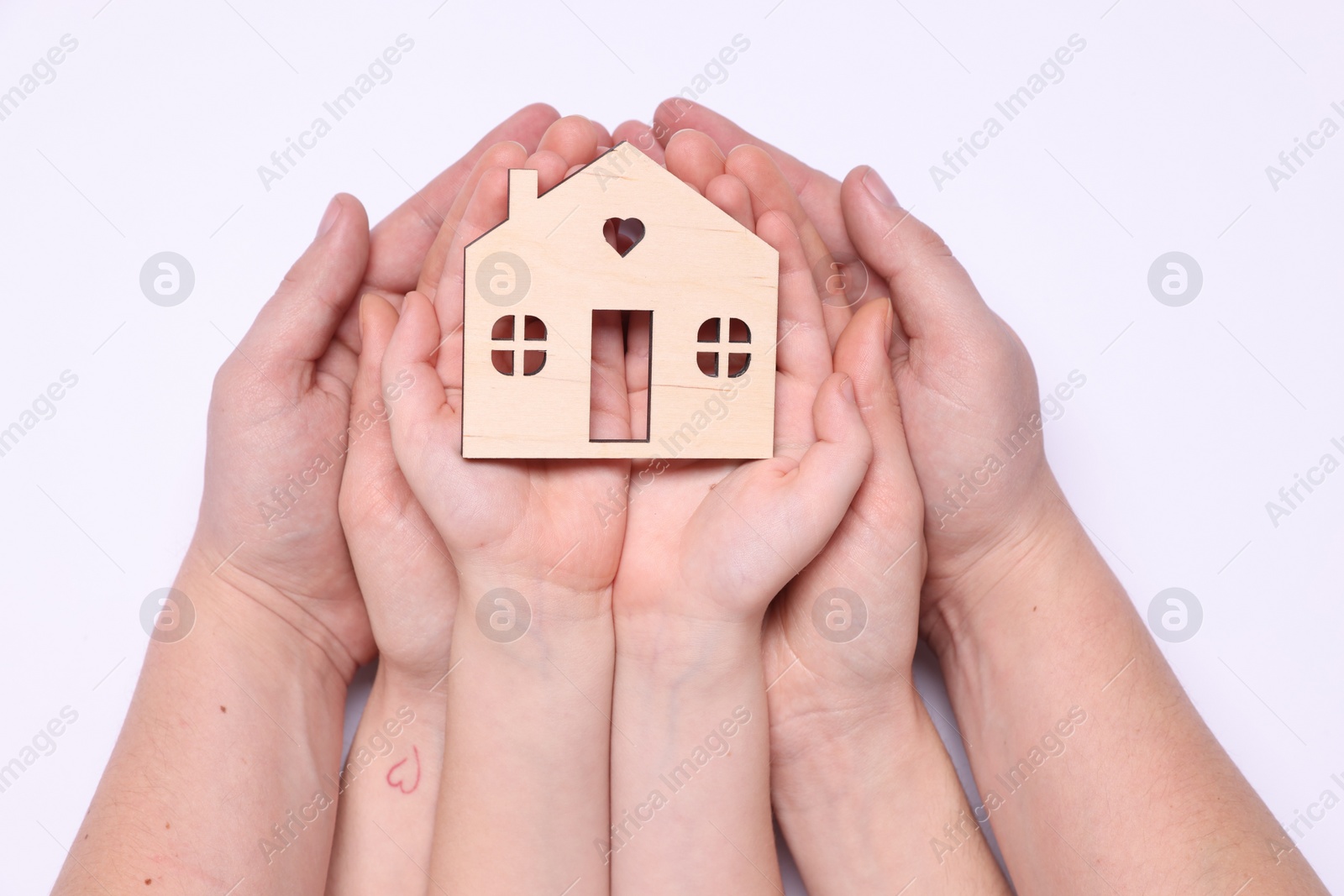 Photo of Home security concept. Family holding house model on white background, top view