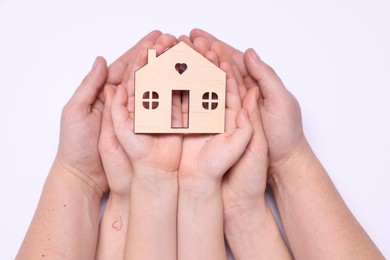 Photo of Home security concept. Family holding house model on white background, top view