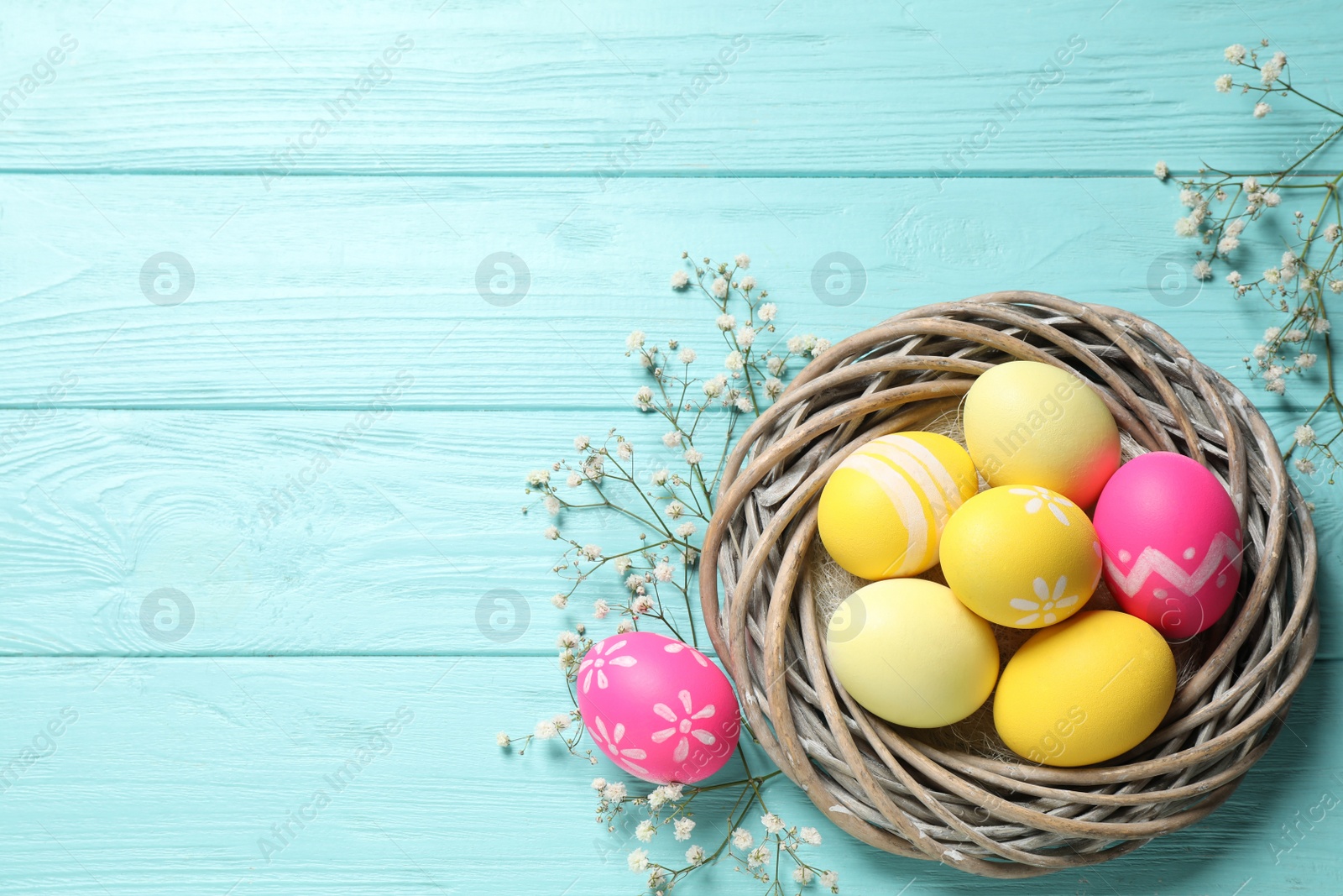 Photo of Flat lay composition with Easter eggs on light blue wooden background. Space for text