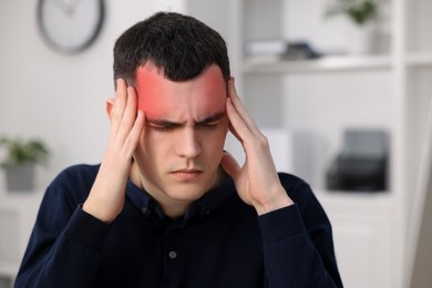 Image of Young man suffering from headache in room