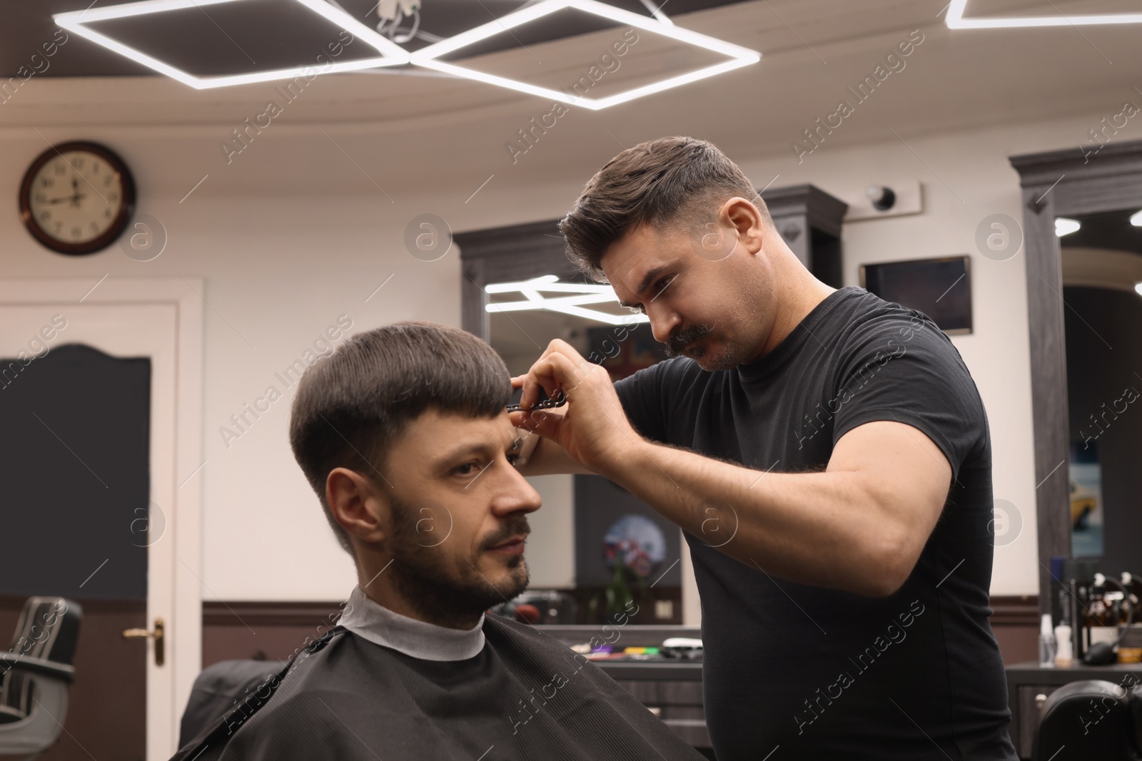 Photo of Professional hairdresser making stylish haircut in barbershop