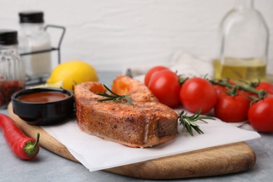 Fresh marinade and cooked fish on grey table, closeup