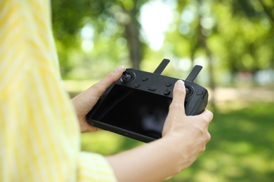 Woman holding new modern drone controller outdoors, closeup of hands