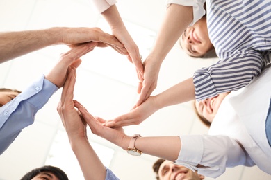 Photo of People putting their hands in circle on light background. Unity concept