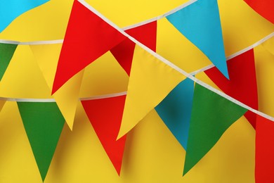 Buntings with colorful triangular flags on yellow background