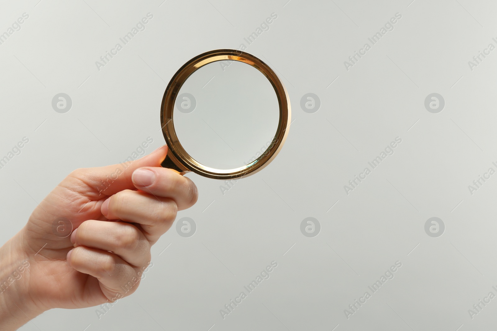 Photo of Woman holding magnifying glass on white background, closeup. Space for text