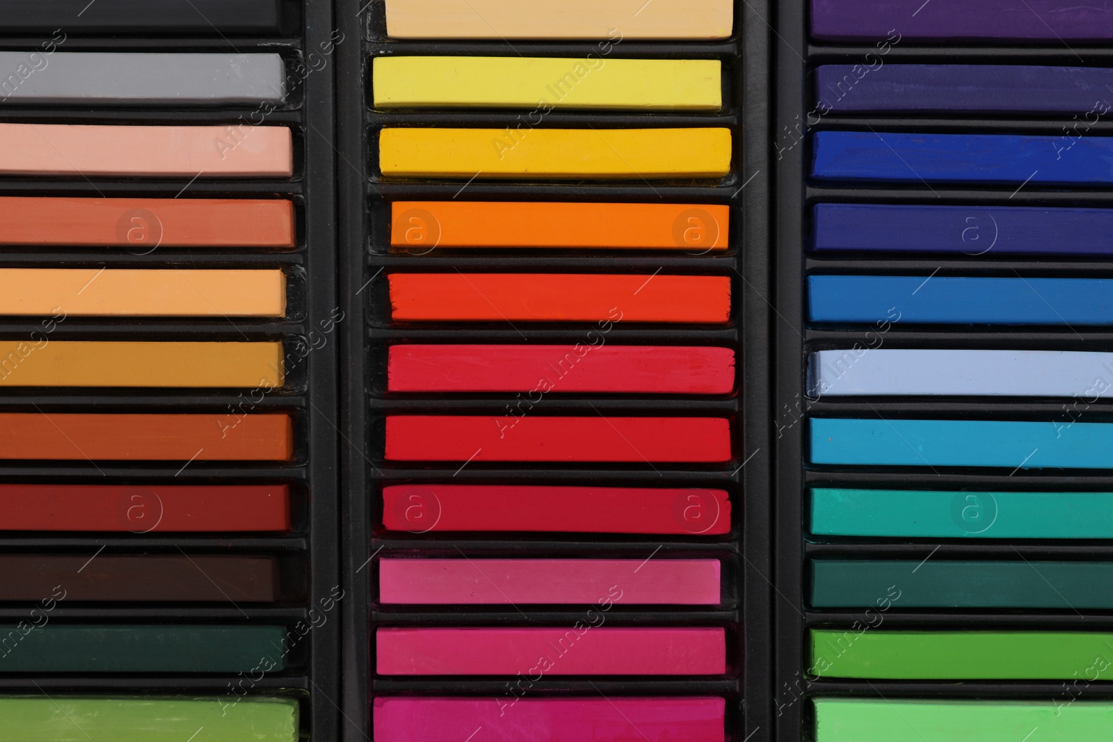 Photo of Set of colorful pastels in trays as background, top view. Drawing materials