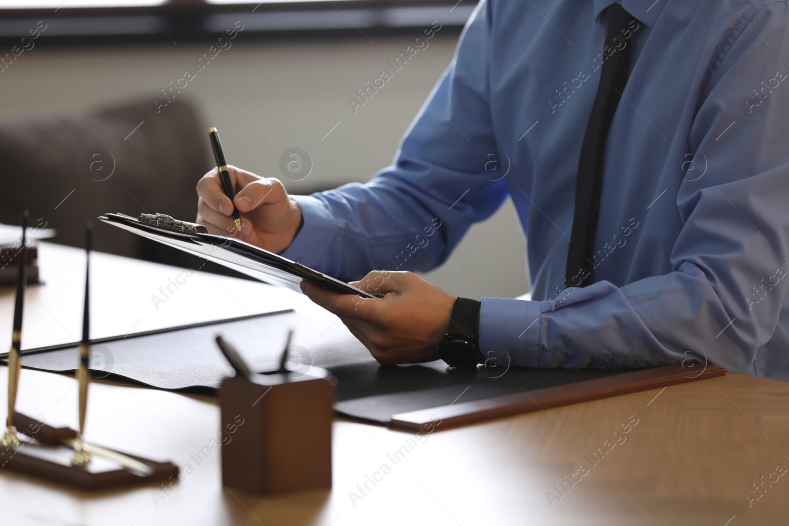 Photo of Male lawyer working at table in office, closeup