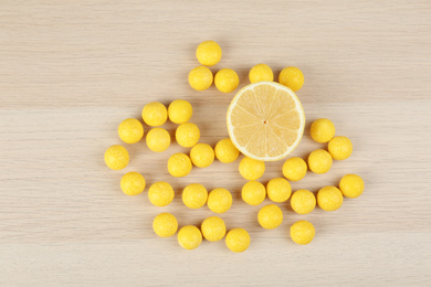 Photo of Flat lay composition with tasty lemon drops on wooden table