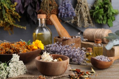 Many different dry herbs on wooden table