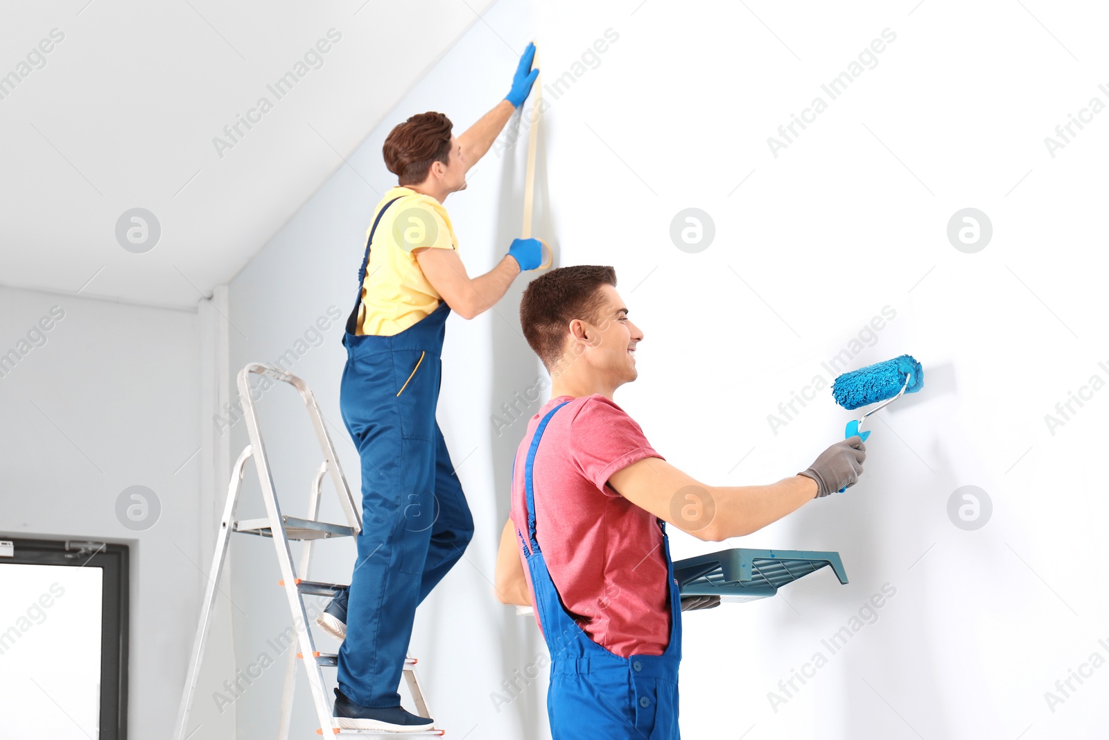 Photo of Male decorators refurbishing empty room