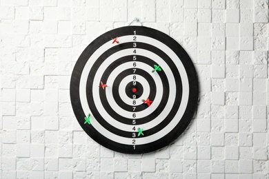 Arrows hitting dart board on white textured wall