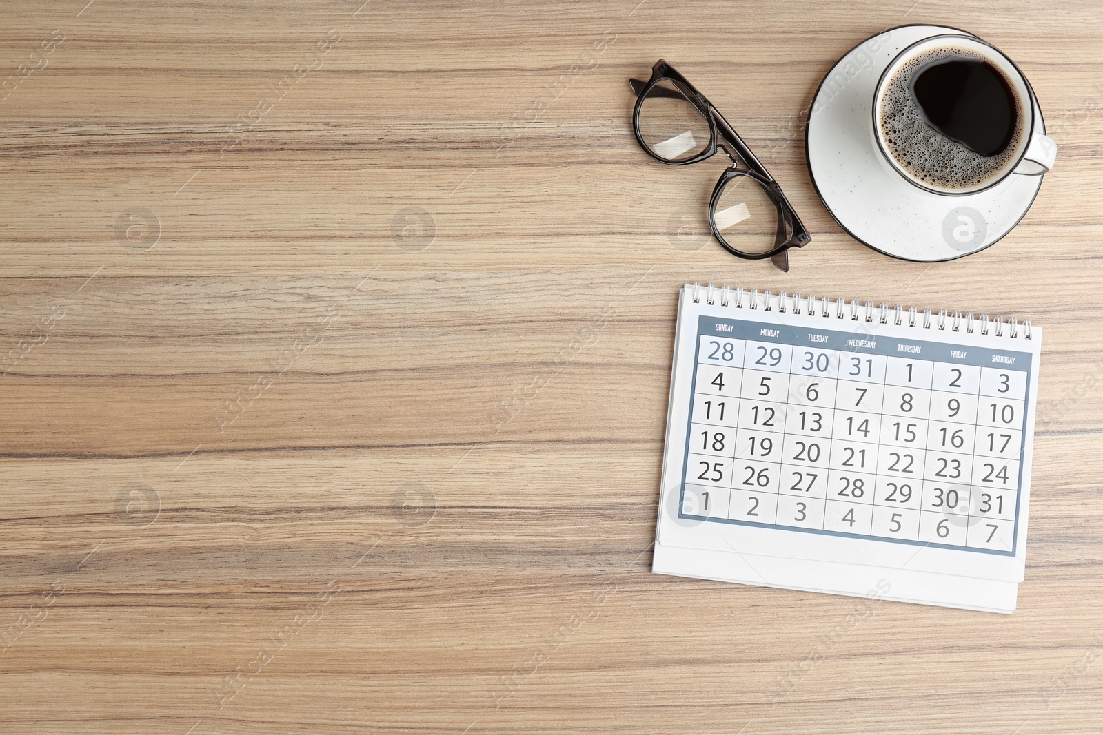 Photo of Flat lay composition with calendar on wooden table. Space for text