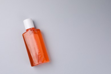 Photo of Fresh mouthwash in bottle on grey background, top view. Space for text