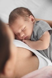 Photo of Young woman holding her newborn baby, closeup