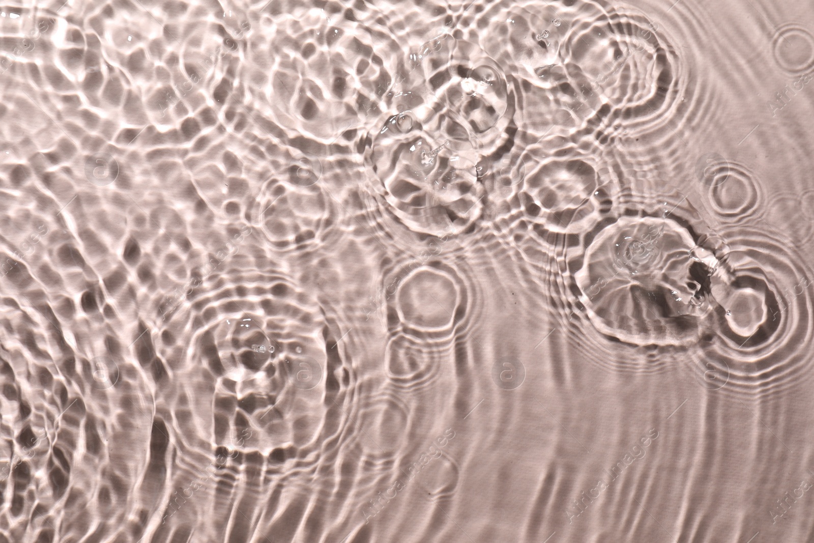 Photo of Rippled surface of clear water on beige background, top view