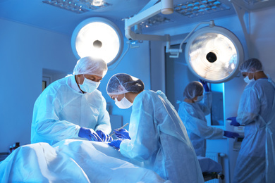 Team of professional doctors performing operation in surgery room