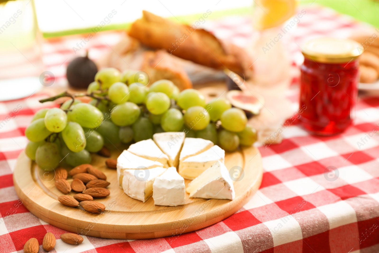 Photo of Different tasty food on picnic blanket, closeup