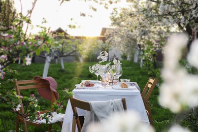 Stylish table setting with beautiful spring flowers in garden