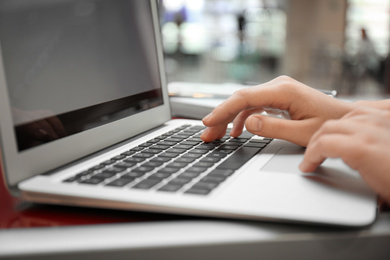 Photo of Blogger working with laptop in cafe, closeup