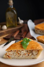 Photo of Slice of delicious meat pie with basil on table, space for text