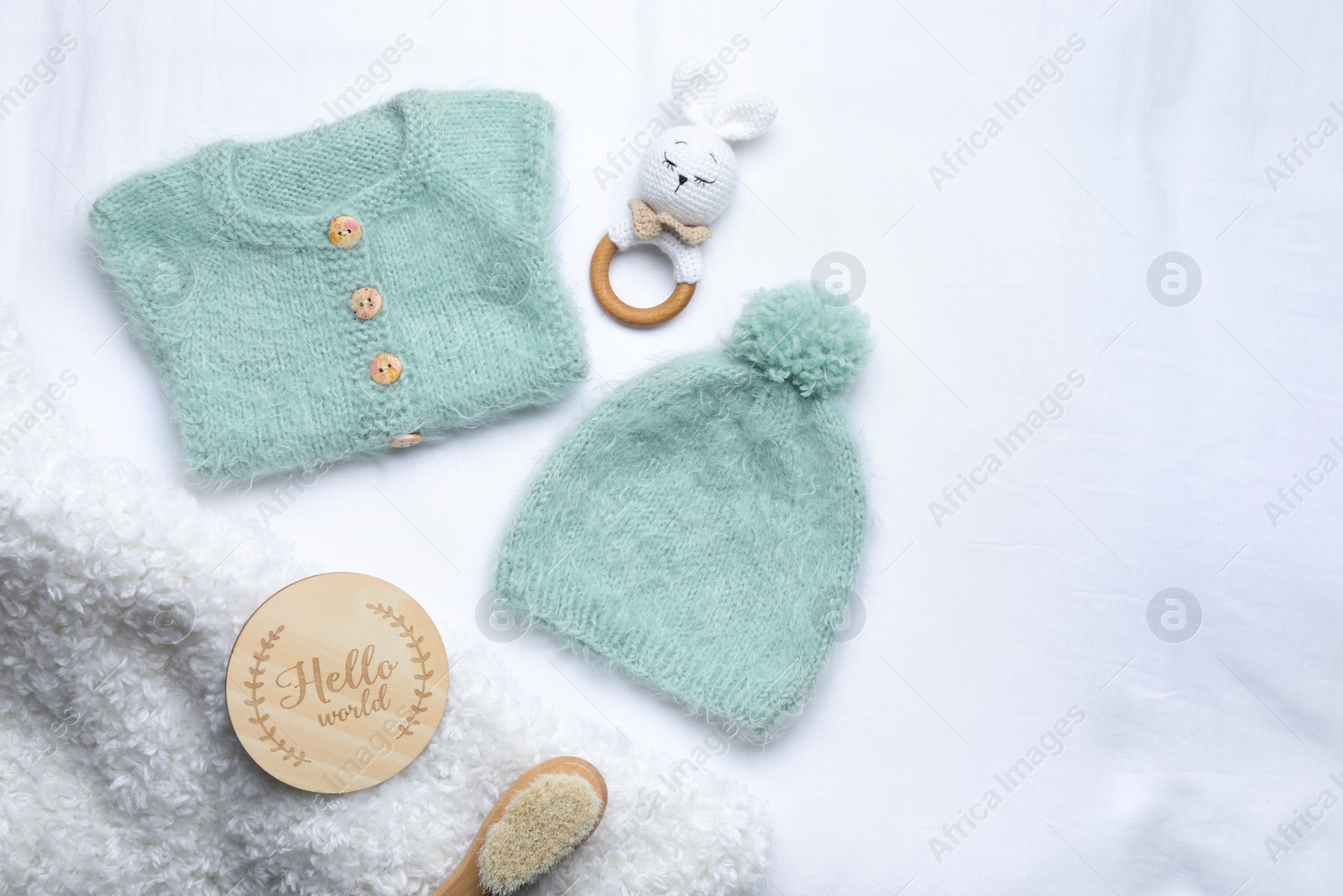 Photo of Flat lay composition with child's clothes and accessories on white fabric, space for text