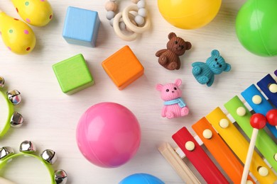 Photo of Baby song concept. Wooden tambourines , xylophone and toys on table, flat lay