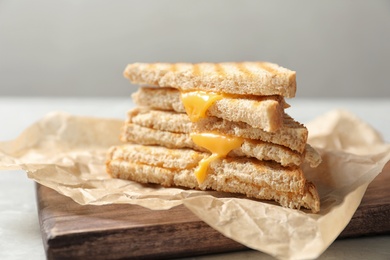 Photo of Wooden board with fresh cheese sandwiches on table