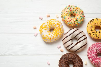 Yummy donuts and space for text on white wooden background, flat lay