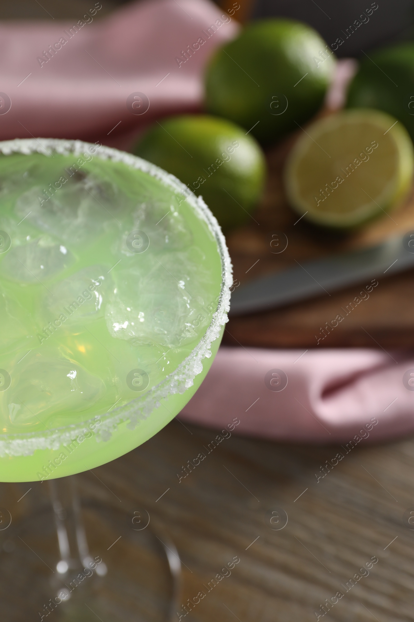 Photo of Delicious Margarita cocktail in glass on wooden table, closeup