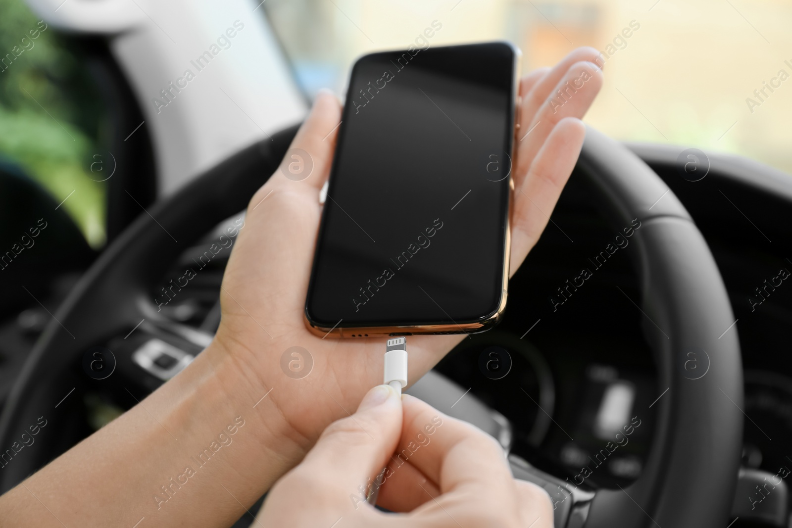 Photo of Person charging phone with USB cable in car